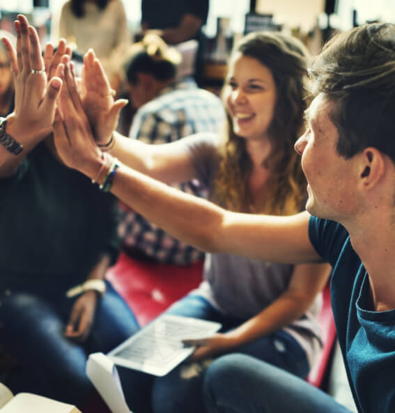 Students sitting in a circle giving a group high five